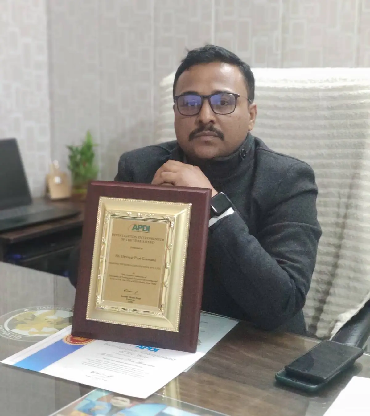 Patna Detective Services agency owner with award at office.